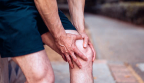 Imagem de uma pessoa com as mãos no joelho sentindo dor